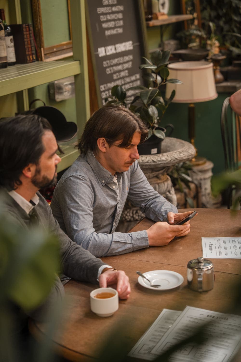 Unyfy team members checking a phone over coffee